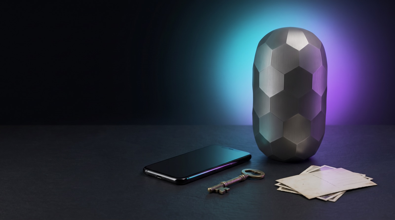 The Inheritans titanium capsule next to a switched-off phone, an antique key and some old photos turned face down, with a cyan and violet halo of light